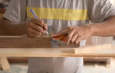 166551026-carpintero-midiendo-tablero-de-madera-con-regla-con-escala-en-taller-trabajos-de-carpinteria-en-la